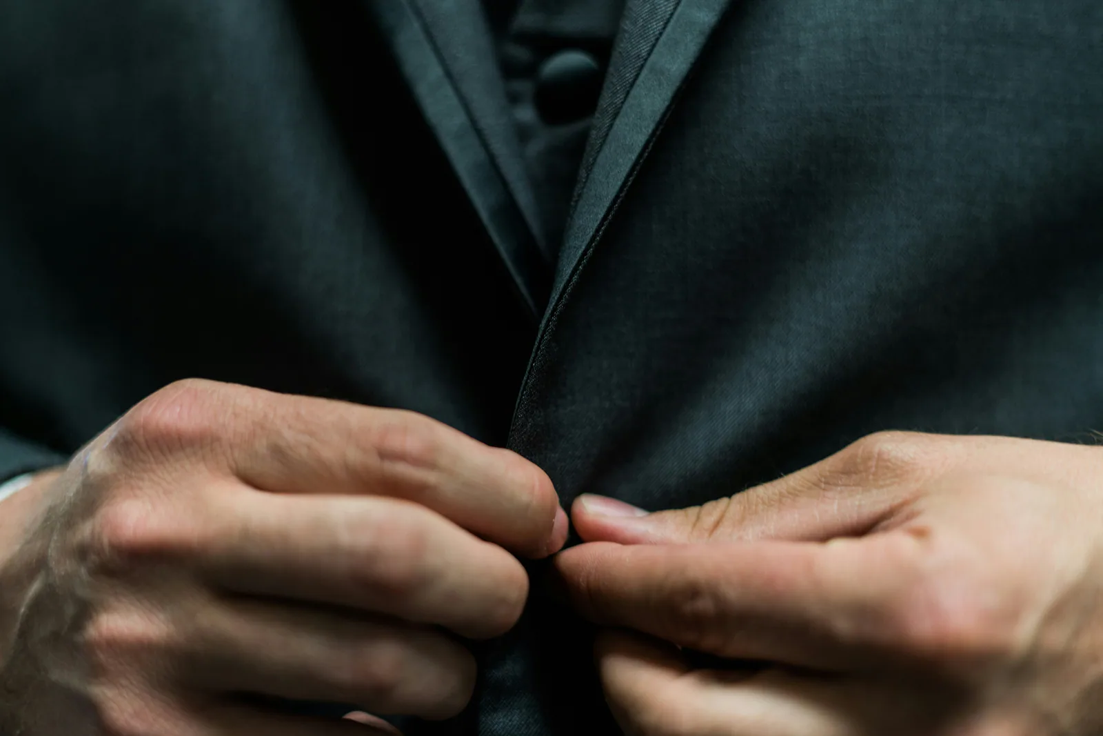 Executive fastening a suit jacket, representing readiness maturity and sponsor-visible professionalism.