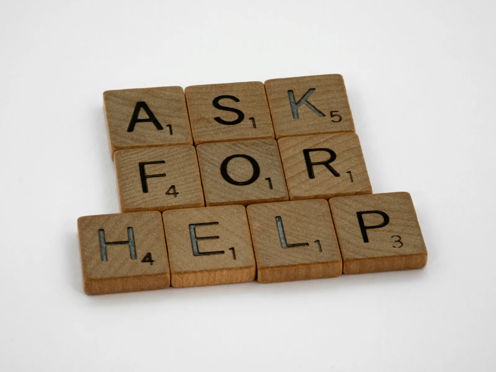 Letter tiles spelling ask for help, representing advisory support and question-led work.