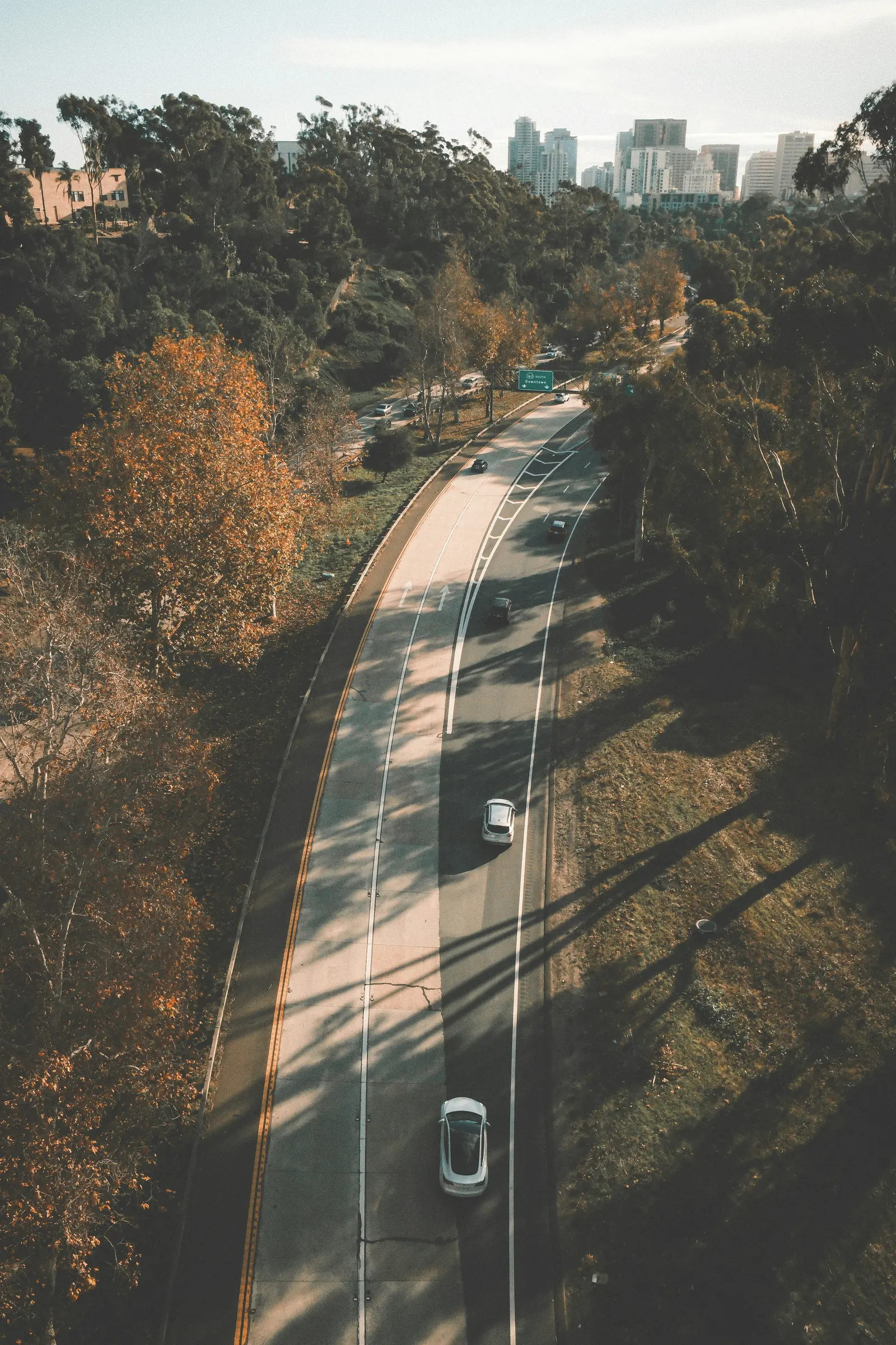 Road corridor through a wooded landscape, representing GCC movement from delivery to strategic capability.