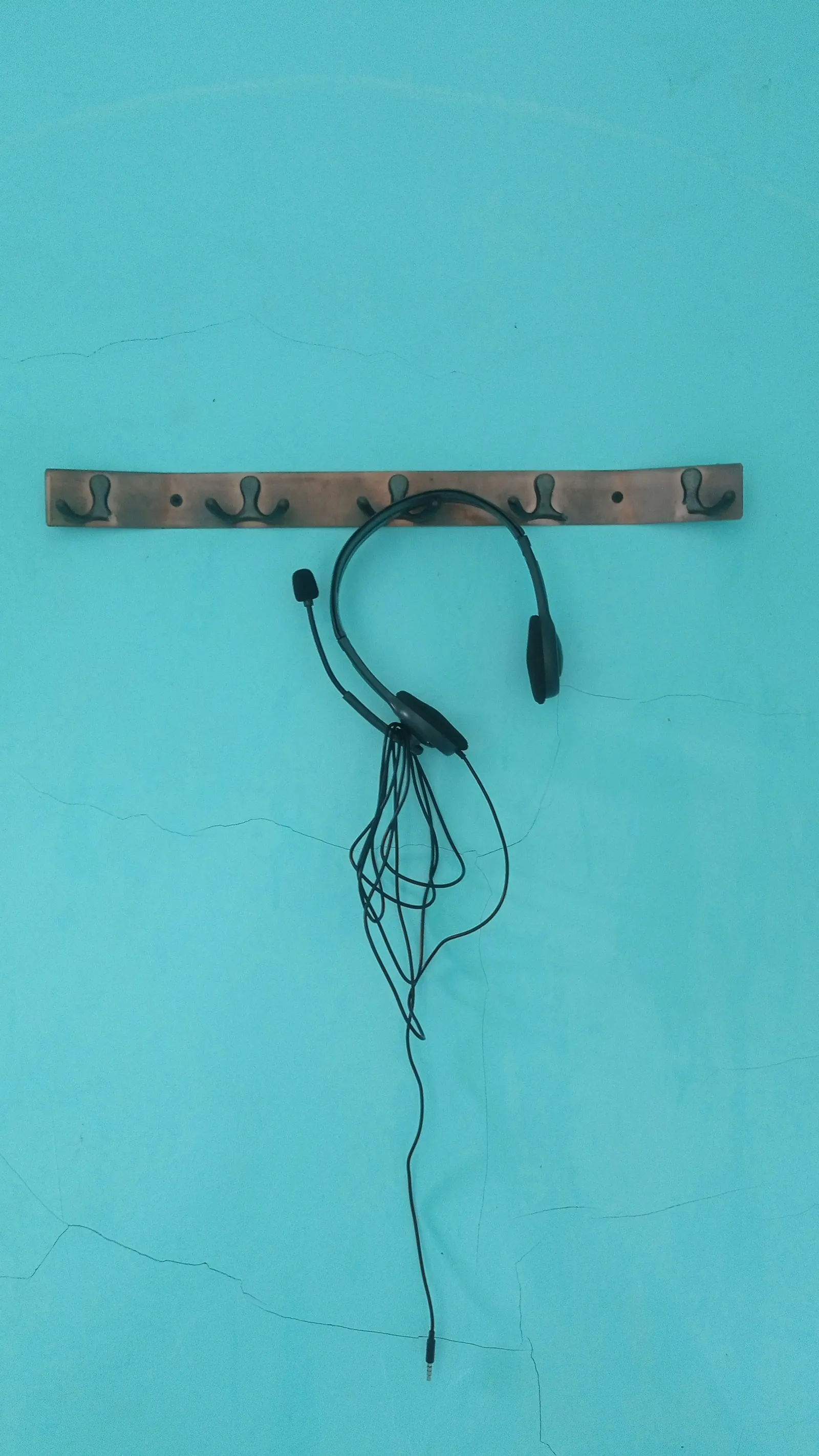 Loose cables on a wall, representing outsourcing complexity and disconnected operating systems.