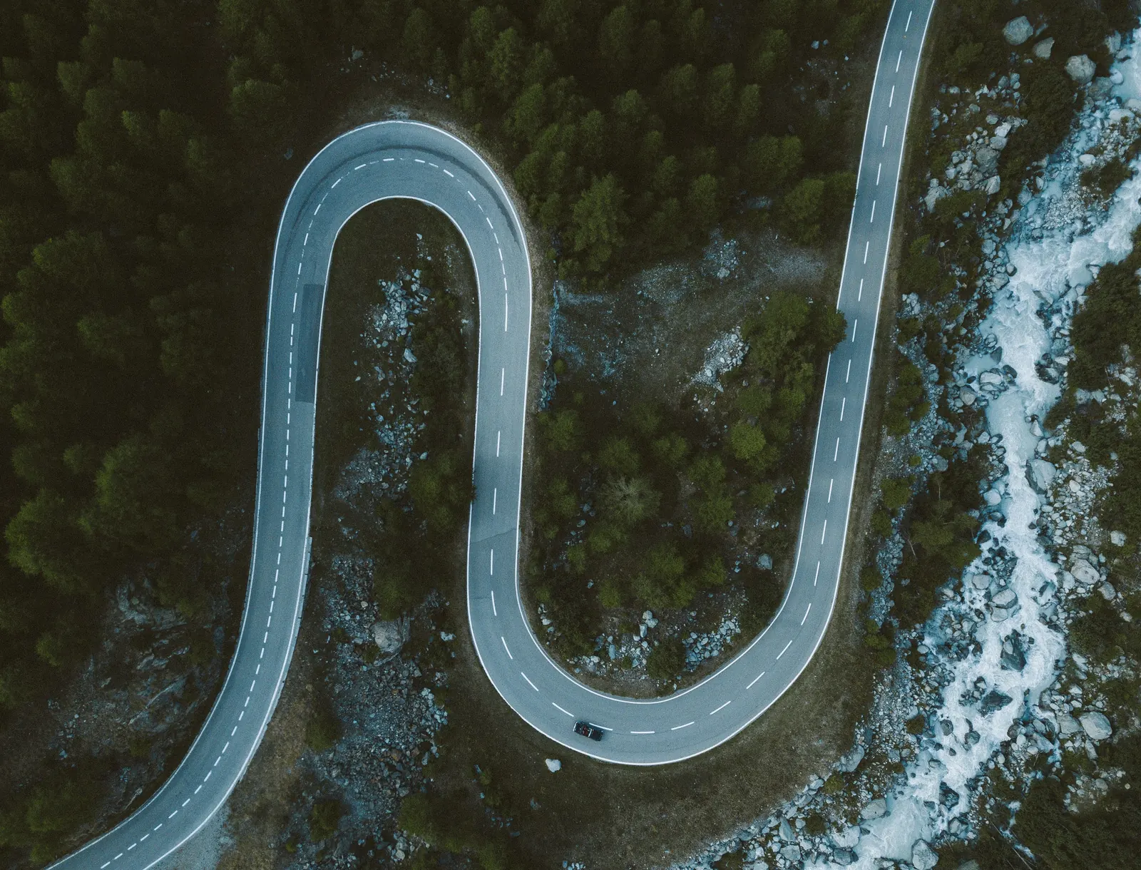 Winding road beside water, representing cross-border execution paths and decision turns.