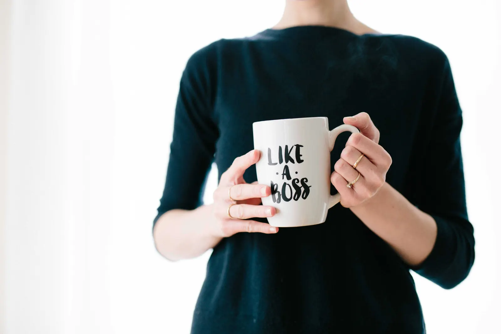 Person holding a leadership-themed mug, representing women leadership development.